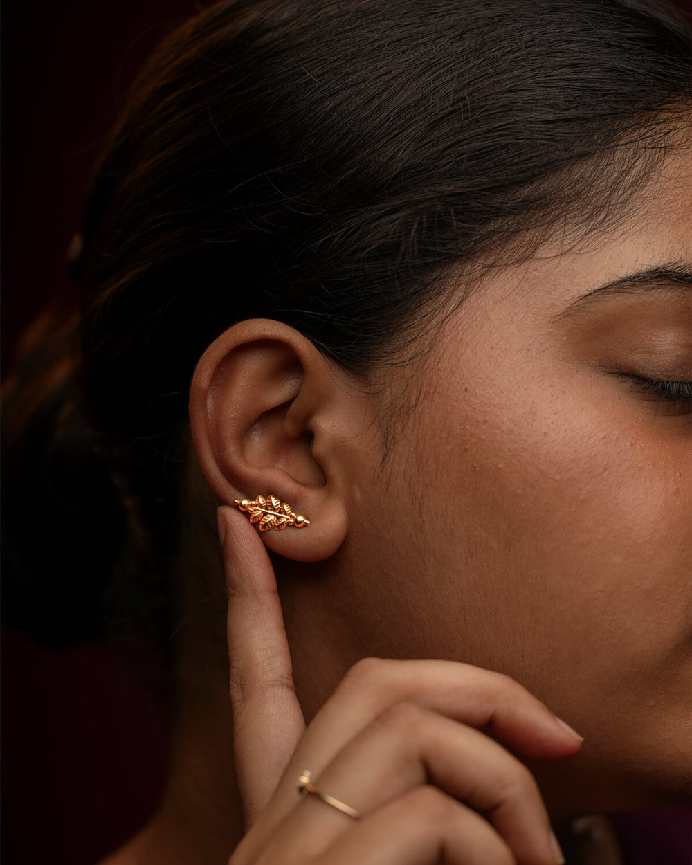 Woman wearing a leaf-shaped gold-plated Parna silver earring